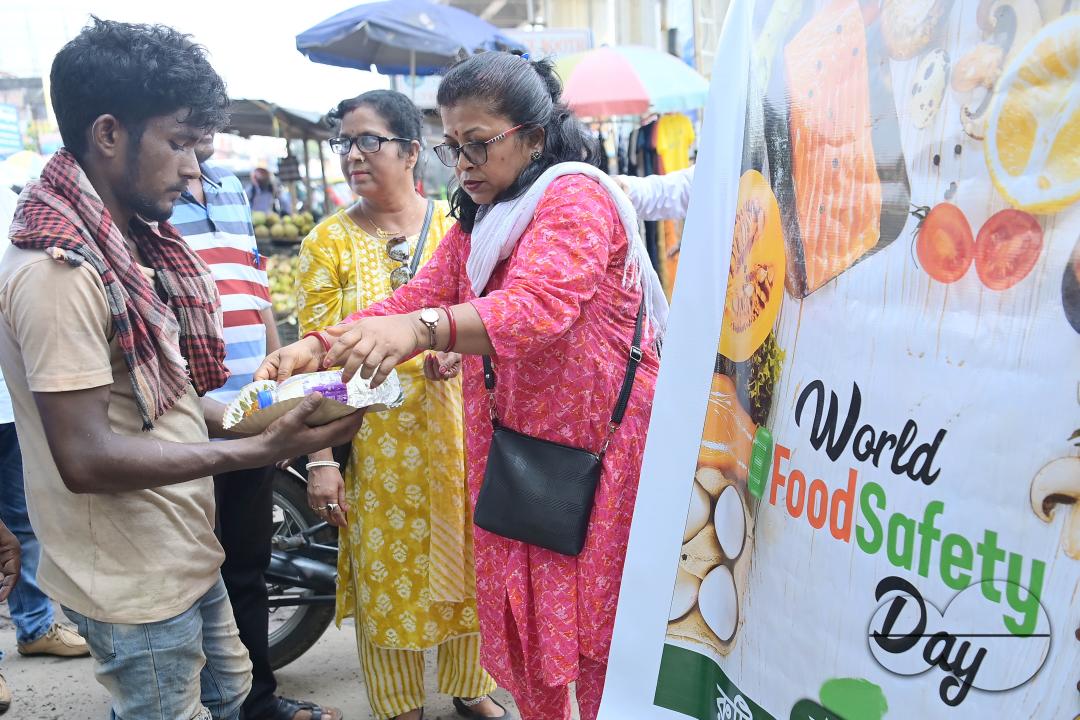 People get food from a social worker on World Food Safety Day, organised by "Roti Bank Foundation", in Agartala