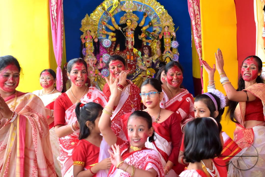 Children and married women are dancing, and the women smear each other with vermillion during a ritual called the vermillion game, or "Sindur Khela," on the last day of the Durga Puja festival in Agartala, Tripura, India.