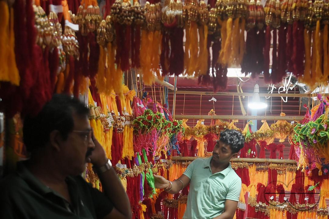 A shop owner arranging "Rakhi", sacred threads for the upcoming "Raksha Bandhan" festival at his shop in Agartala
