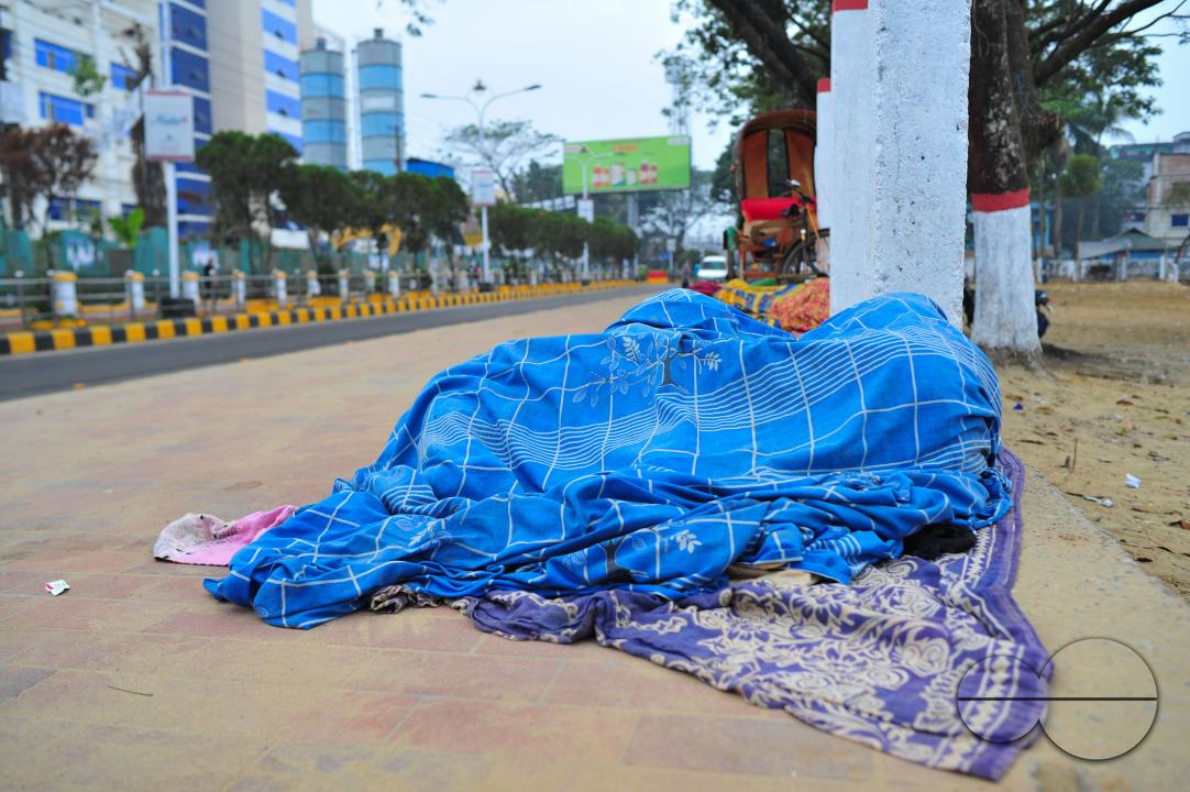 Covering their bodies from head to toe with whatever they can manage, homeless people sleep out in the open in the shivering cold near the Government Alia Madrasa in Sylhet city's Chowhatta area