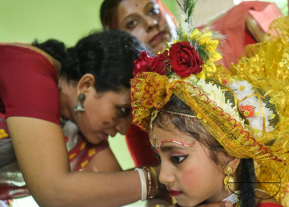 Devotees prepare the nine-year, five-month, and fourteen-day-old Hindu girl Debalina Chakraborty, known as a "Kumari," as she yawns while awaiting worship by priests during Durga Puja at the Ramakrishna Vivekananda Ashram