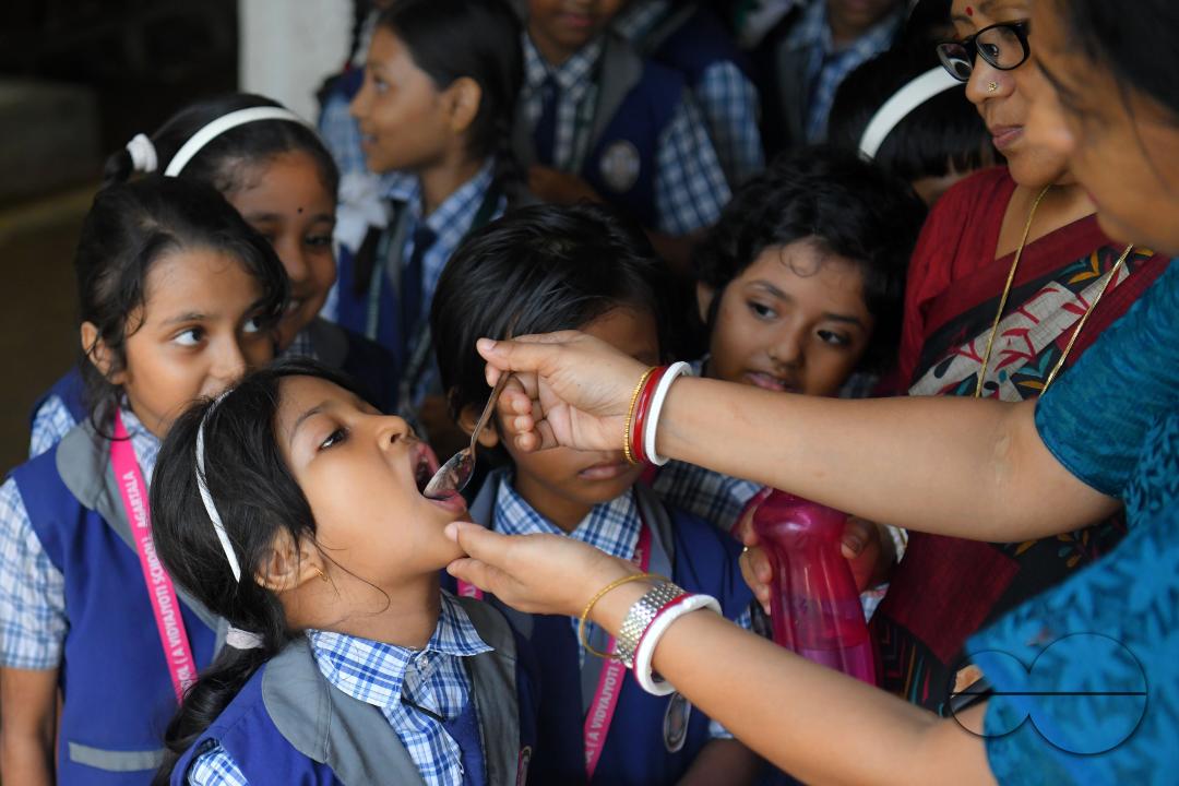A schoolteacher is giving deworming tablets to the students in a school during the special program of Mukhyamantri Sustho Shoishob, Sustho Kaishore Abhiyan (MSSSKA 5'0) for National Deworming Day
