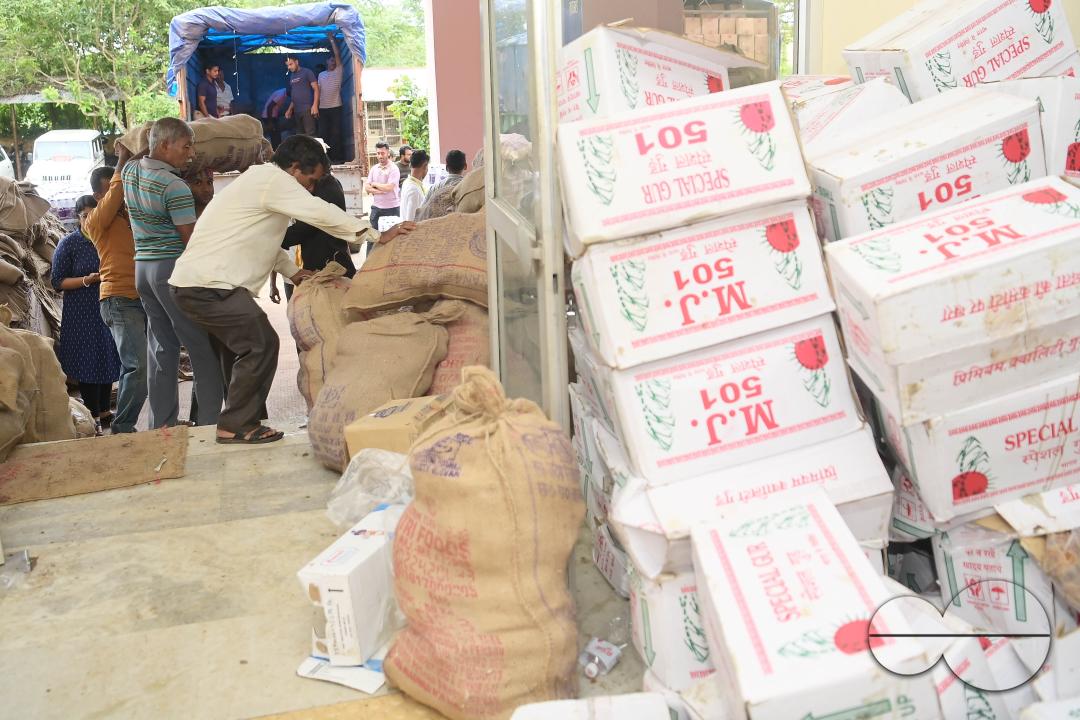 Laborers are carrying packets of food and stacking them in a truck as government officials and workers prepare food packets to be distributed by NDRF (National Disaster Response Force) personnel from helicopters to flood victims in different parts of Tri