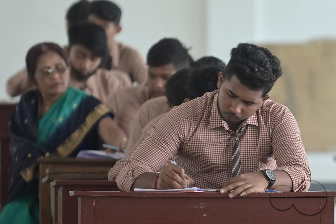 Students are seen writing an English paper