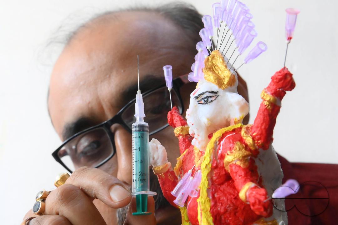 Samiran De, an artist works on an idol of Lord Ganesha made with soup and syringe needles to alert people against drugs, ahead of Ganesh Chaturthi festival, in Agartala