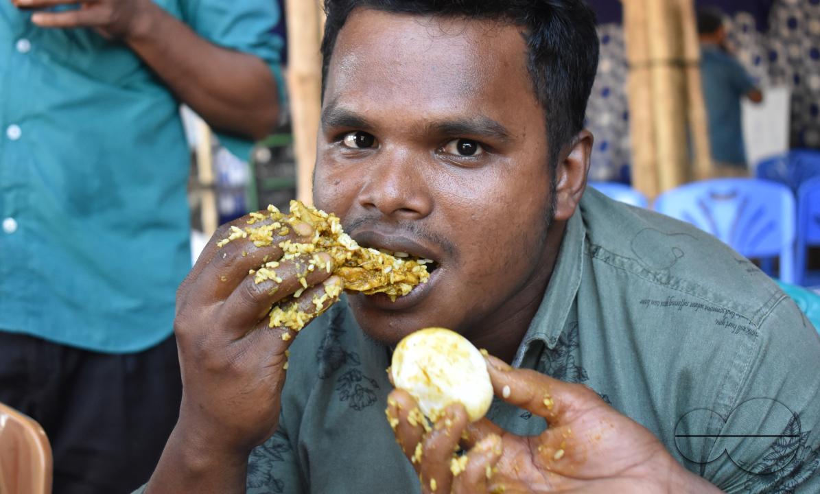 Portrait of  a man eating chicken at the Balukhali refugee camp