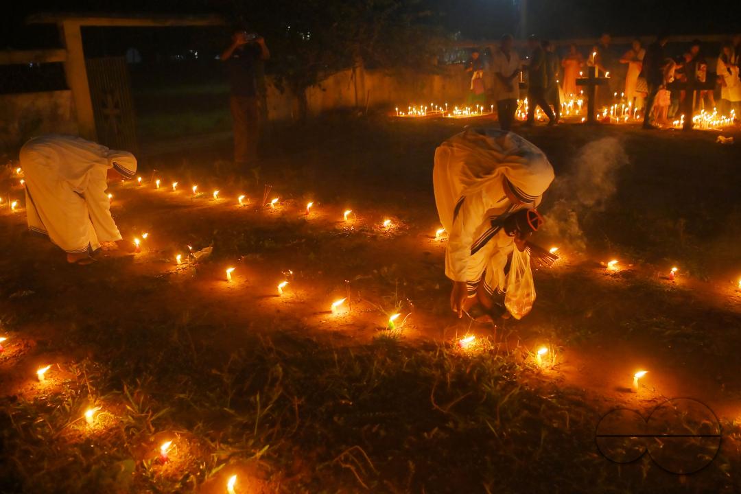 Nuns offer prayers next to the graves of their family members at a cemetery during "All Souls Day" on the outskirts of Agartala