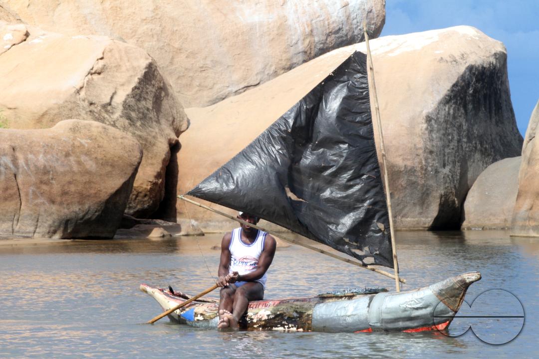 A fisherman seated on his canoe that is powered by a plastic sail on Lake Malawi, Senga Bay