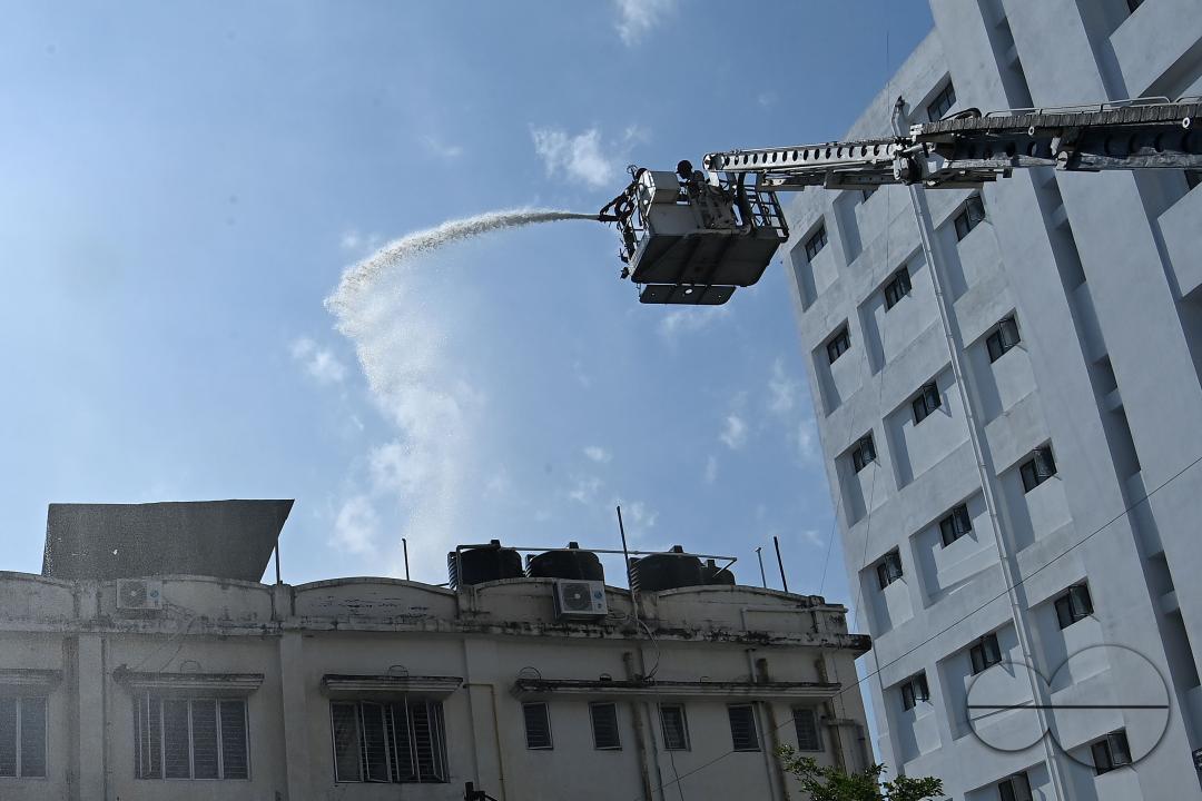 Fire brigade personnel are trying to control a fire on the top of the building of the dental college during a state level mock exercise on earthquake day at Agartala