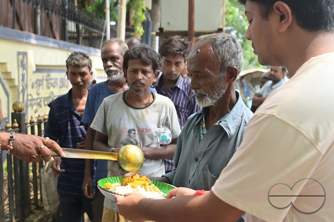 People get food from a social worker on World Food Safety Day, organised by Rotary Club of Agartala, in Agartala
