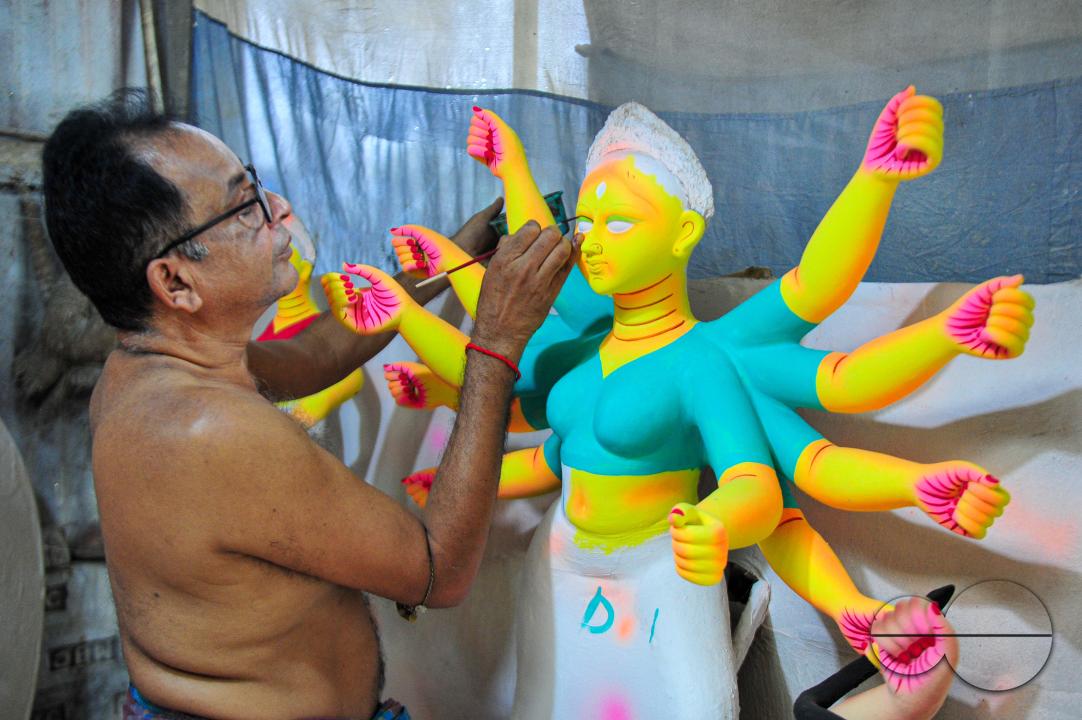 Dulal Paul, a veteran Idol Artist is colouring structures of a Hindu Deity in preparation for the upcoming Durga Puja Festival