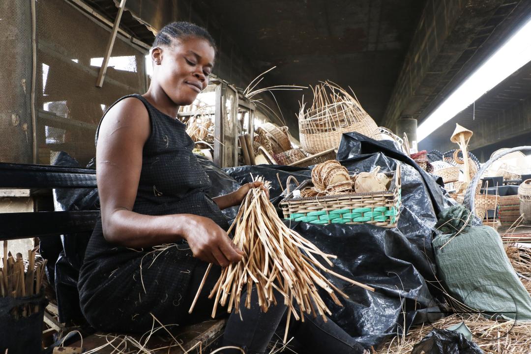 A woman processes cane wood for weaving at Nigeria's largest cane 'village' at Mende in the Maryland District of Lagos