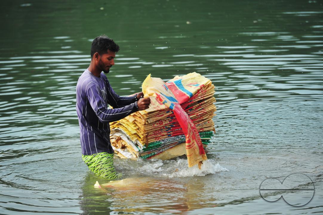 Women are risking their lives to wash cement bags beside the Surma River in Sylhet
