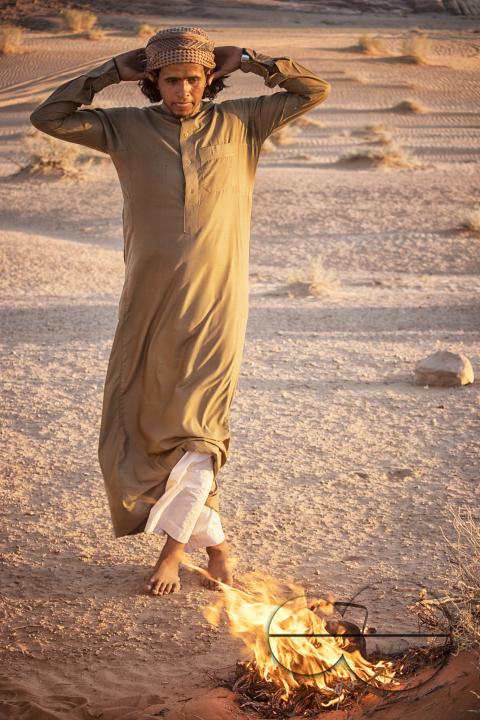A male bedouin dancing in front of a fire in the desert of Wadi Rum