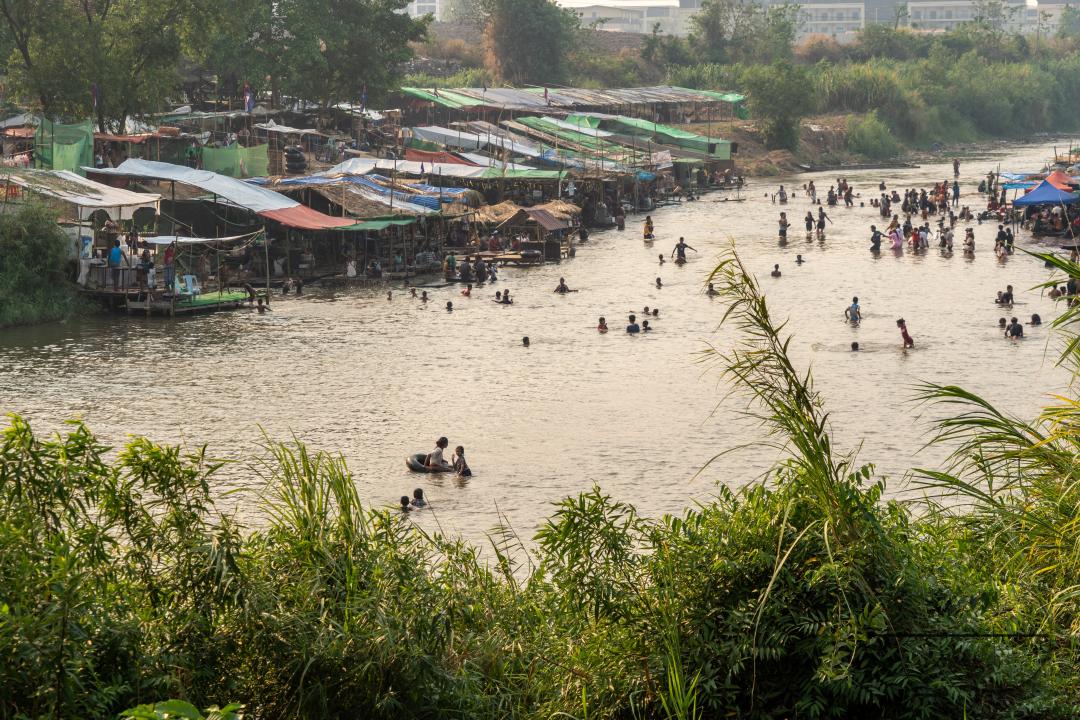 Thai and Burmese families swimming and playing in the Thailand - Myanmar Moei river border near Mae Sot, Thailand.
