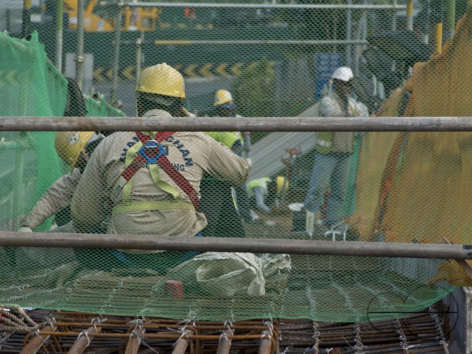 Migrant workers at a construction site by a highway in Singapore