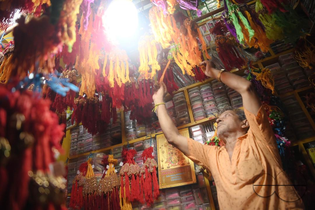 A shop owner arranging "Rakhi", sacred threads for the upcoming "Raksha Bandhan" festival at his shop in Agartala
