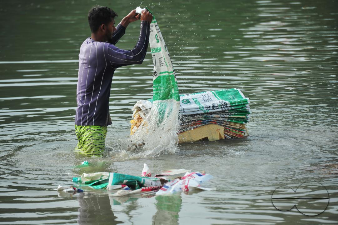 Women are risking their lives to wash cement bags beside the Surma River in Sylhet