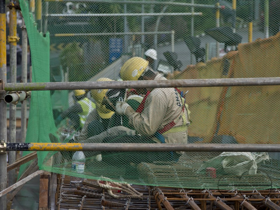 Migrant workers at a construction site by a highway in Singapore