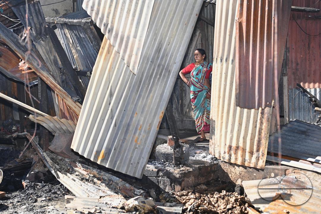 Shop owners and vendors are seen in front of their burnt shops and vegetables stalls in Battala market, the second biggest market in Tripura