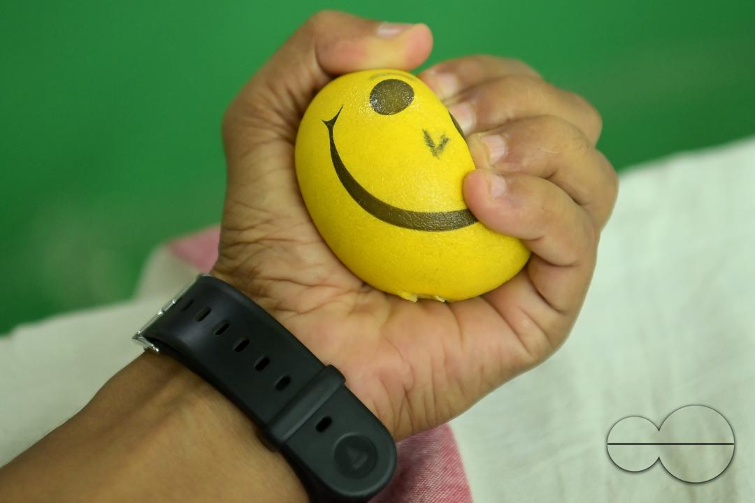 A man squeezes a sponge ball as he donates blood on World Blood Donor Day at a blood donation centre in Agartala