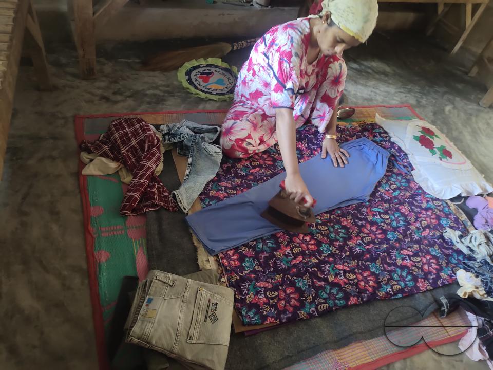 A woman ironing with an old fashioned charcoal iron at the Balukhali refugee camp