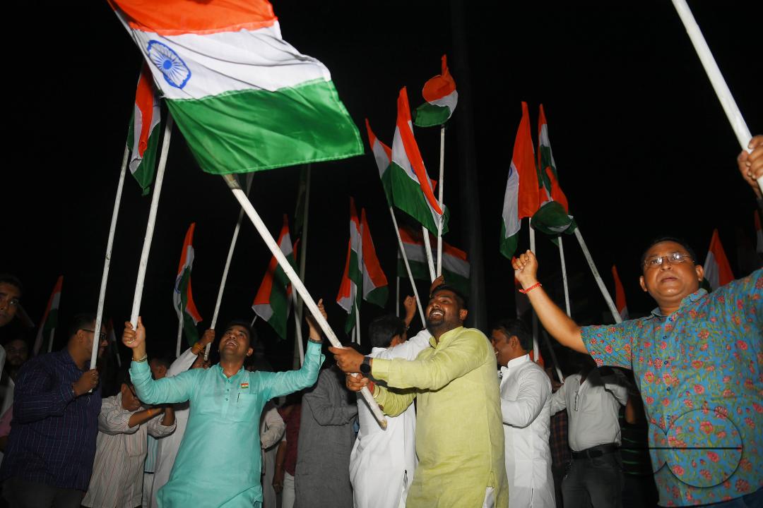 BJP party leaders, workers and the general public celebrate with the Indian flag in front of a LCD TV during the live stream of the successful lunar landing of the Chandrayaan-3 spacecraft on the south pole of the Moon, in Agartala