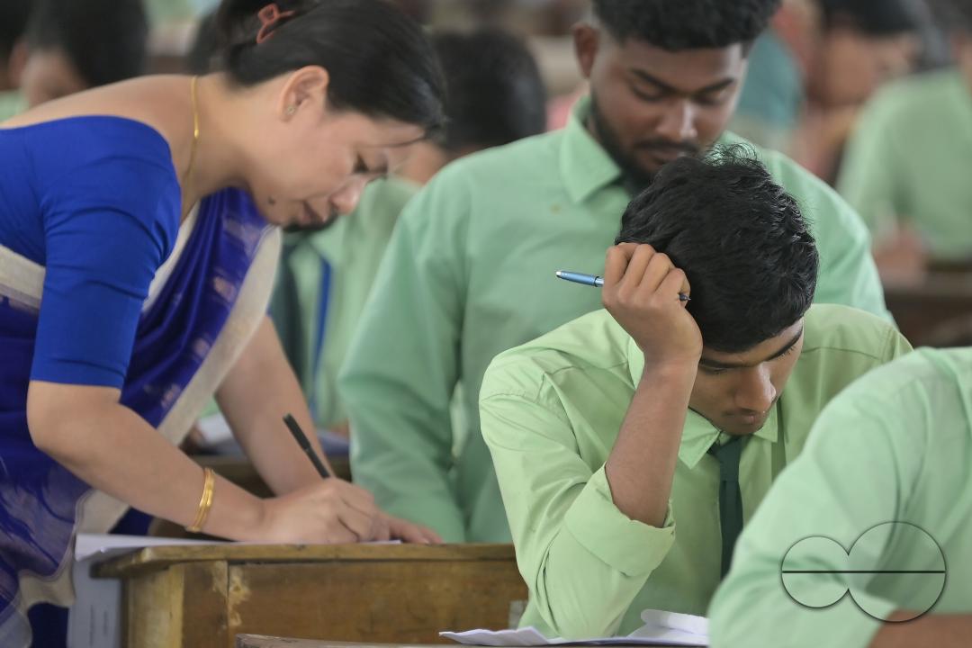 Students are seen writing an English paper