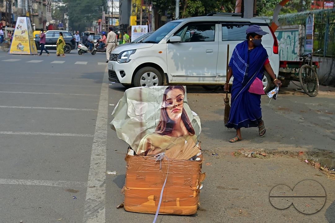 An employee of the municipality sweeps and collects garbage into a collection box in Agartala