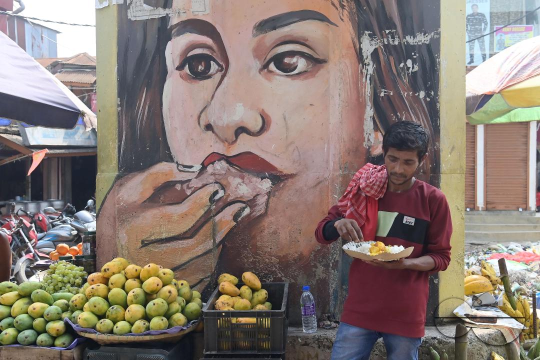 People eating food distributed by a social worker on World Food Safety Day organised by "Roti Bak Foundation", in Agartala