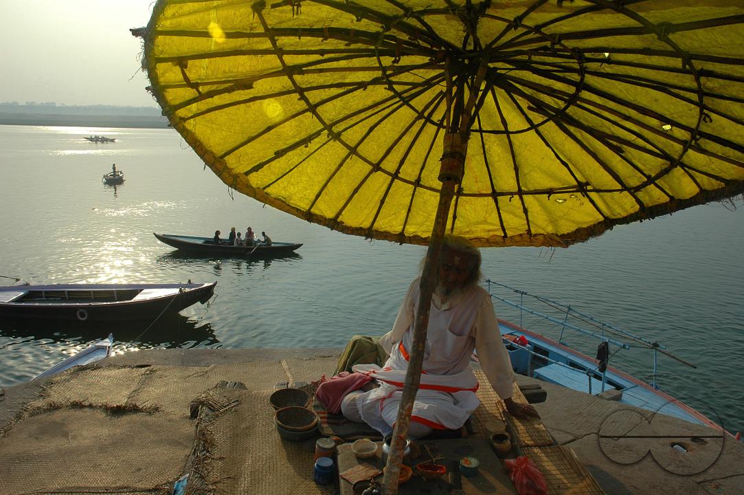 A priest under the traditional umbrella near the Ganga ghat