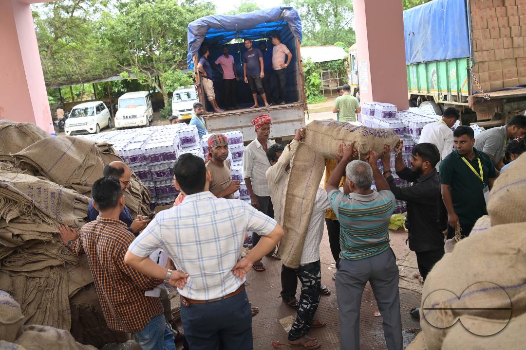 Laborers are carrying packets of food and stacking them in a truck as government officials and workers prepare food packets to be distributed by NDRF (National Disaster Response Force) personnel from helicopters to flood victims in different parts of Tri