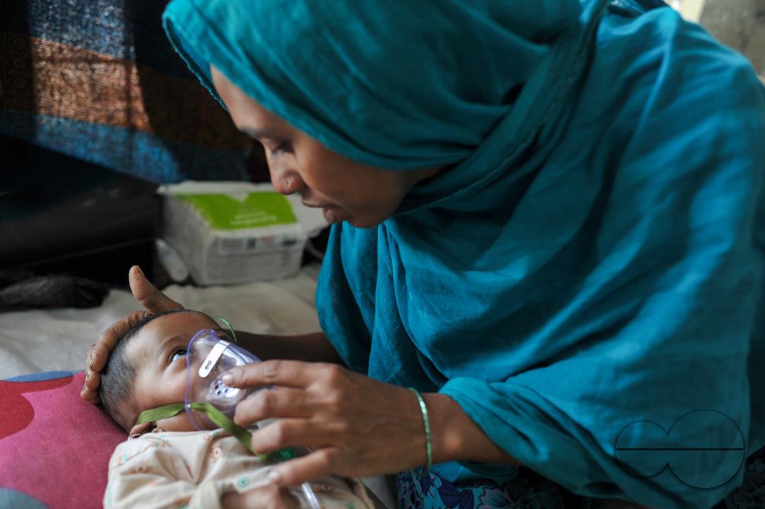 A senior nurse is providing medical care to a child in Sylhet MAG Osmani Medical College Hospital