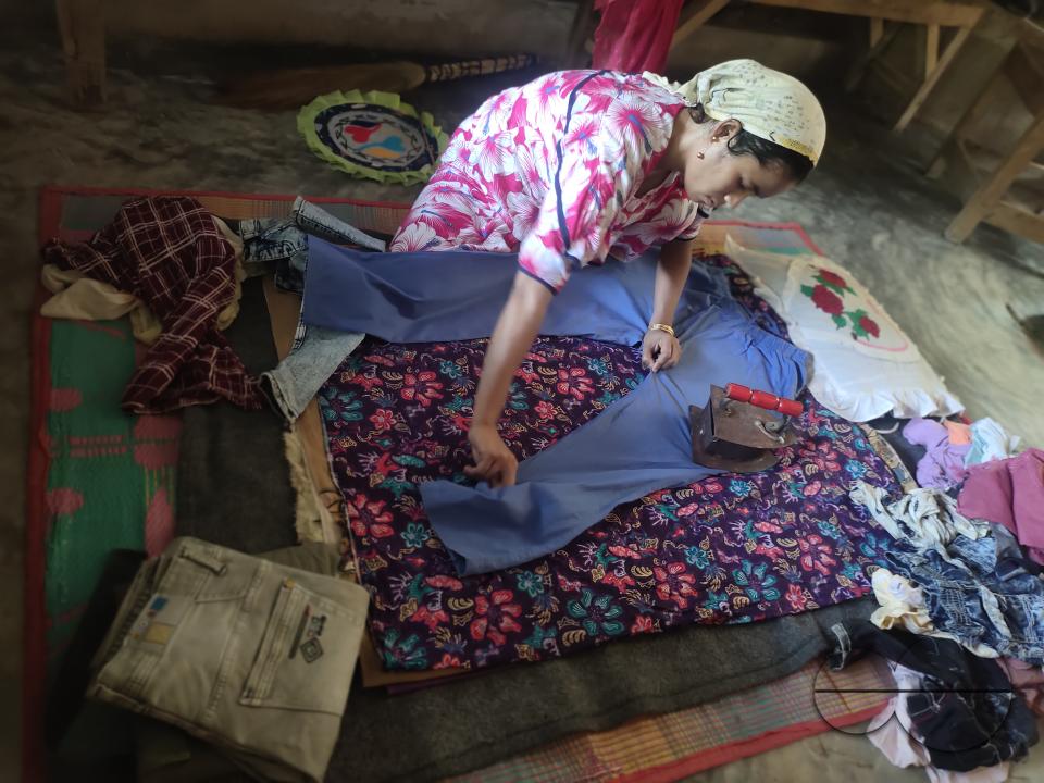 A woman ironing with an old fashioned charcoal iron at the Balukhali refugee camp