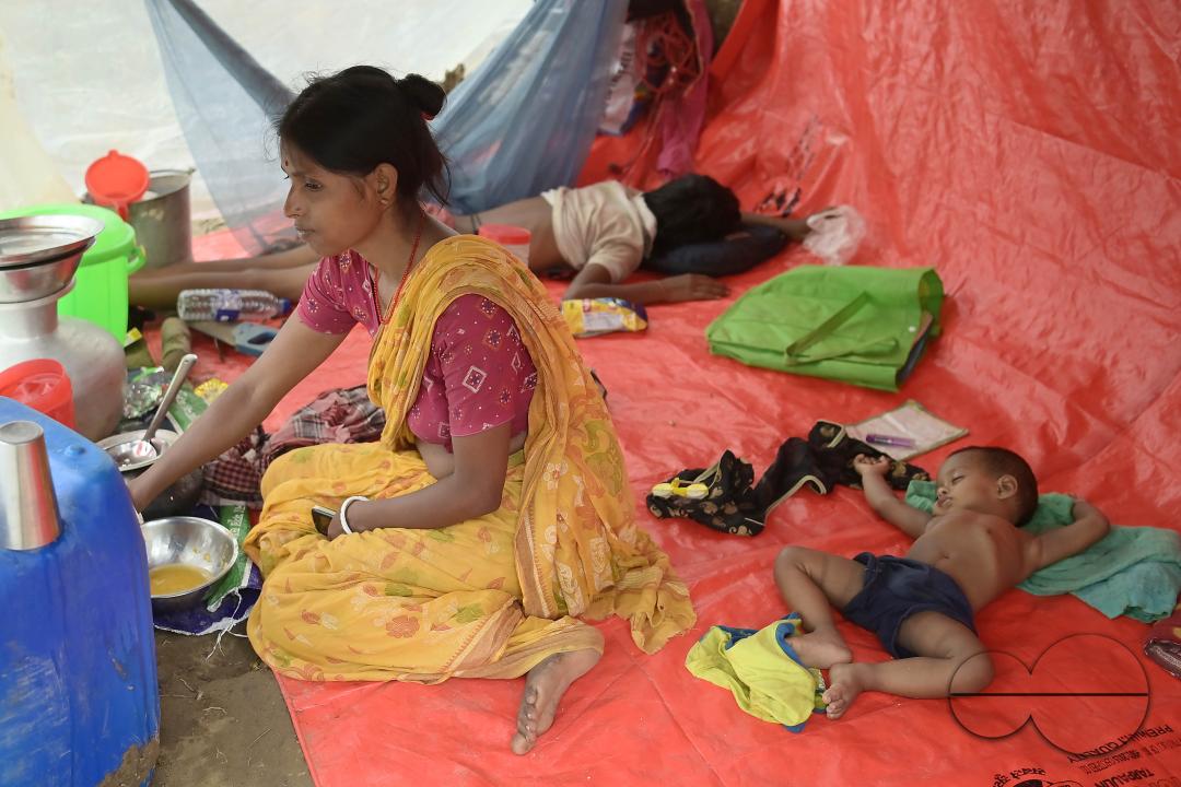 A mother is busy with her children's inside a makeshift tent at Panisagar's reserve forest
