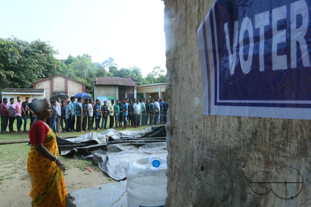 Voters wait in a queue to cast their votes during the by-elections for the Boxonagar assembly seat, in Tripura Sepahijala district