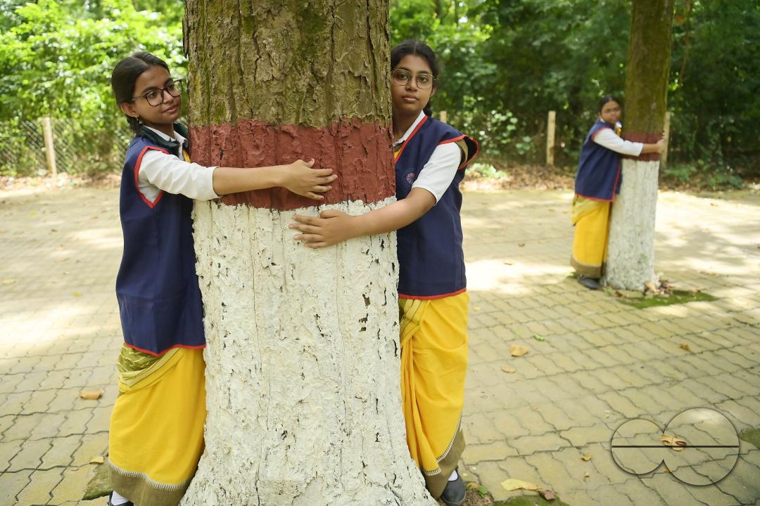 NSS (National Service Scheme) volunteers and school students of Netaji Subhas Vidyaniketan hug trees on the eve of World Nature Conservation Day
