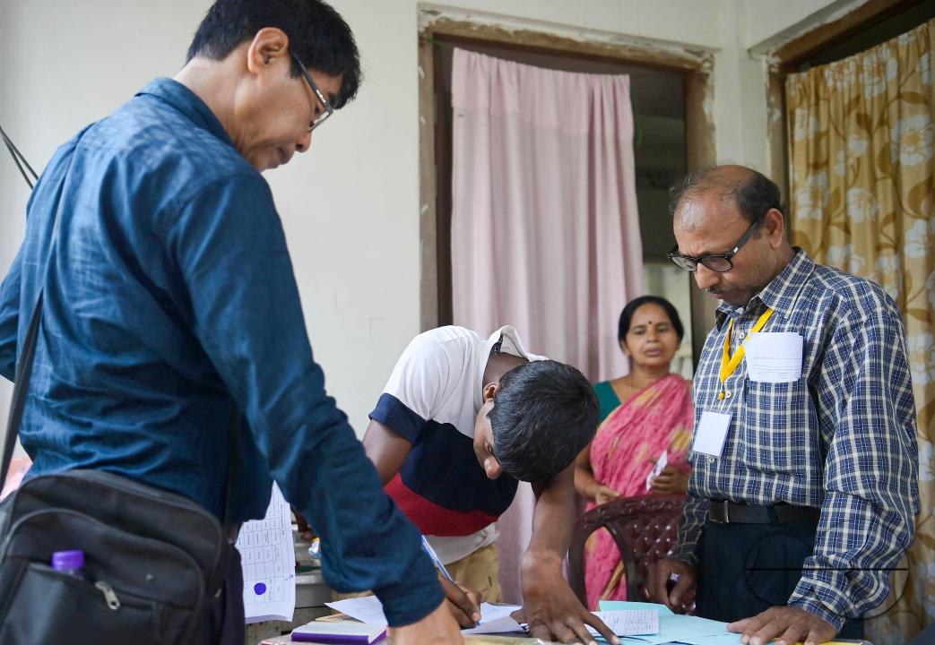 A differently abled boy going through the pre vote procedures before casting his postal ballot vote with the assistance of her family members at her house in front of the team of election officials and security personnel in Agartala