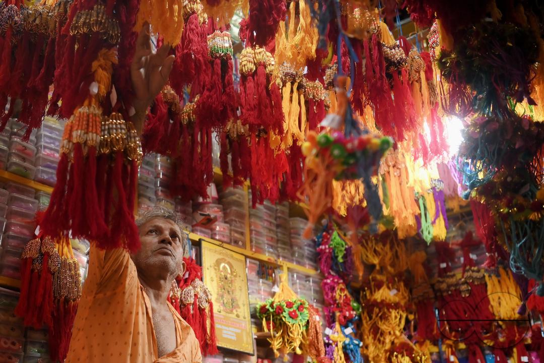 A shop owner arranging "Rakhi", sacred threads for the upcoming "Raksha Bandhan" festival at his shop in Agartala