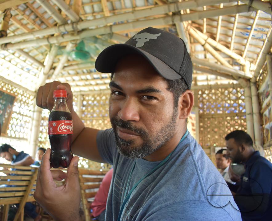 Portrait of a man showing a bottle of coke at the Balukhali refugee camp