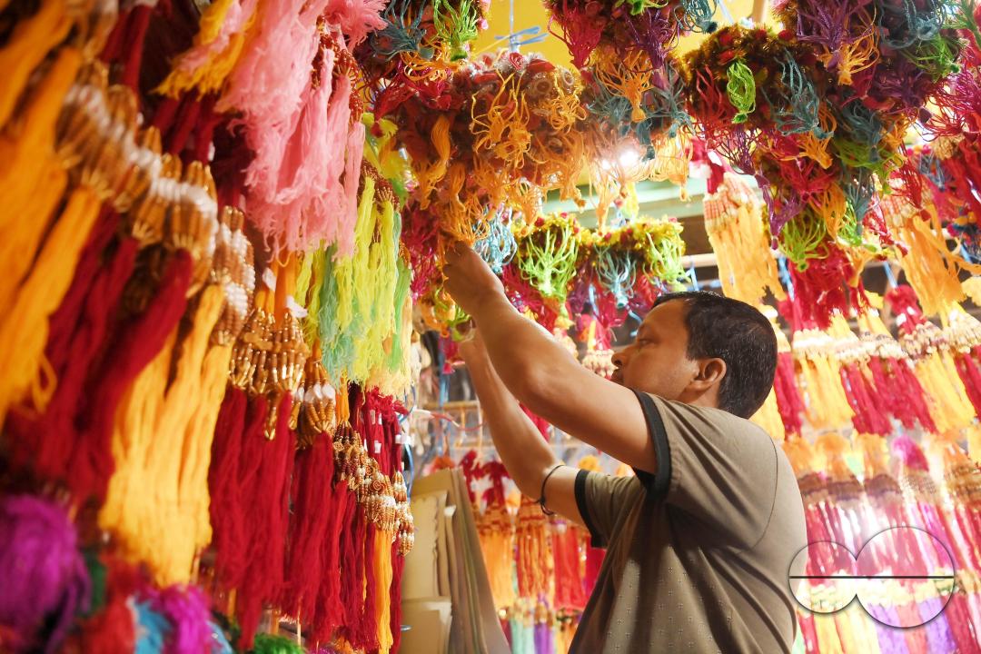 A shop owner arranging "Rakhi", sacred threads for the upcoming "Raksha Bandhan" festival at his shop in Agartala