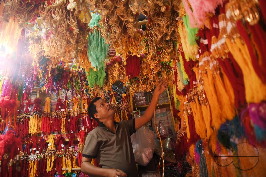 A shop owner arranging "Rakhi", sacred threads for the upcoming "Raksha Bandhan" festival at his shop in Agartala
