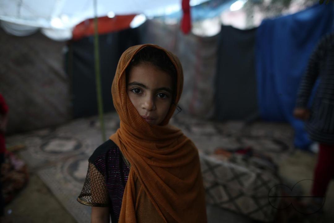 A Palestinian displaced child woke up to the rainwater that drowned the tent she lives in after being displaced due to the war