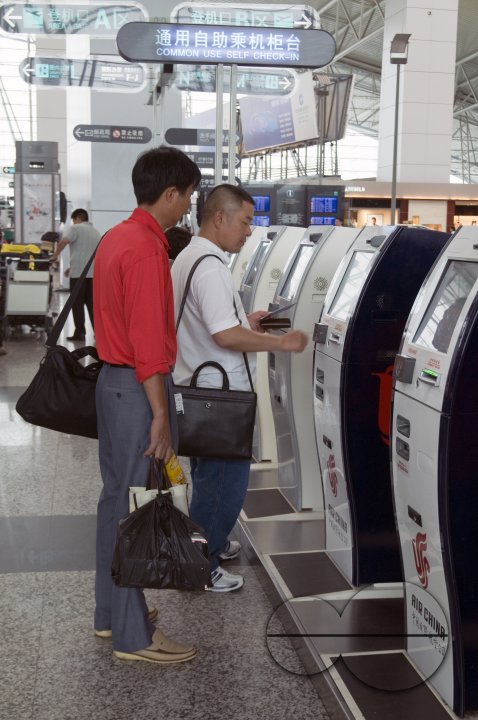 CHINA Passengers using automated checking in machines at the new terminal of the international airport of Guangzhou, Guangdong province.