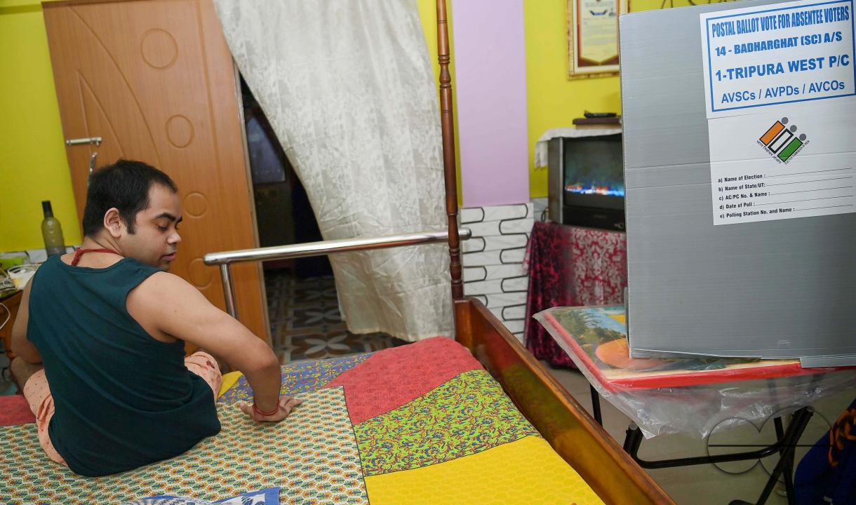 A differently abled boy casting his postal ballot vote at his house in front of the team of election officials and security personnel in Agartala