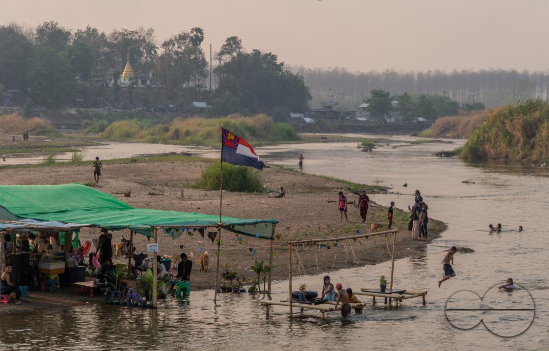 Thai and Burmese families swimming and playing in the Thailand - Myanmar Moei river border near Mae Sot, Thailand.