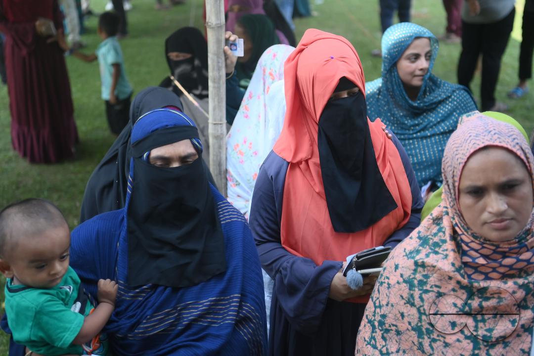 Voters wait in a queue to cast their votes during the by-elections for the Boxonagar assembly seat, in Tripura Sepahijala district