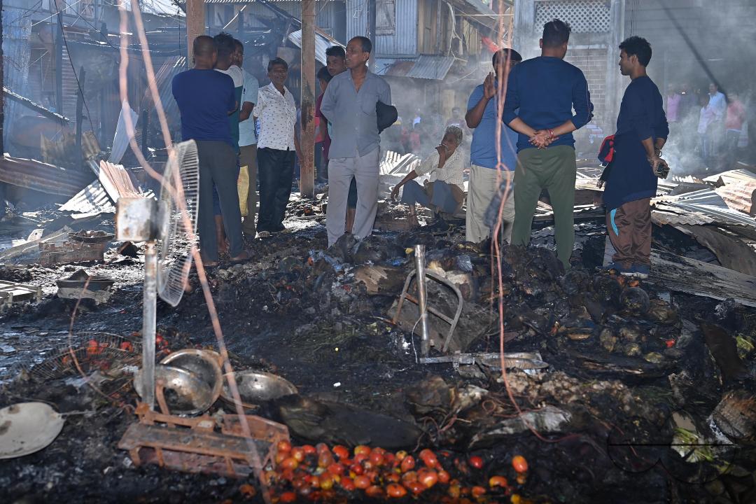 Shop owners and vendors are seen in front of their burnt shops and vegetables stalls in Battala market, the second biggest market in Tripura