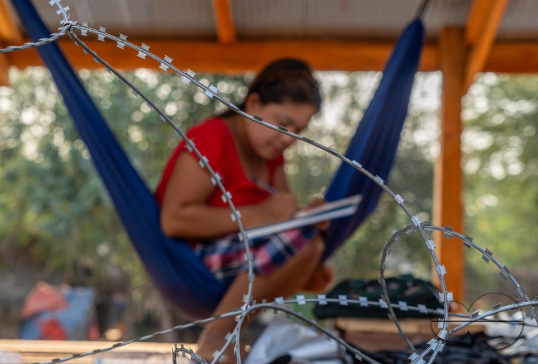 Visitors, traders and illegal Burmese immigrants walk by barbed wire at the Thai side of the Thailand - Myanmar border at Mae Sot, Thailand.