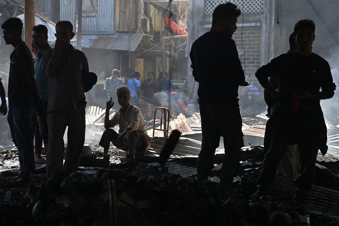 Shop owners and vendors are seen in front of their burnt shops and vegetables stalls in Battala market, the second biggest market in Tripura